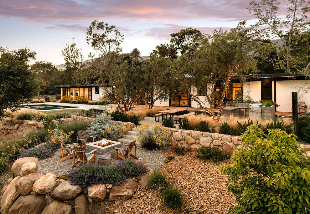 Large midcentury back formal full sun garden in Santa Barbara with a garden path and concrete paving.