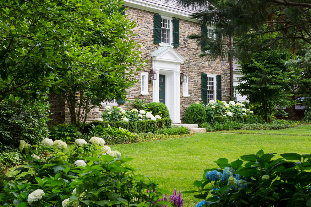 Esempio di un giardino tradizionale di medie dimensioni e davanti casa con un ingresso o sentiero e pavimentazioni in pietra naturale