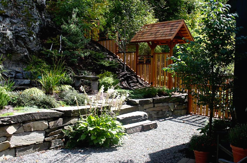 На фото: большой летний участок и сад на заднем дворе в восточном стиле с подпорной стенкой, полуденной тенью и покрытием из гравия