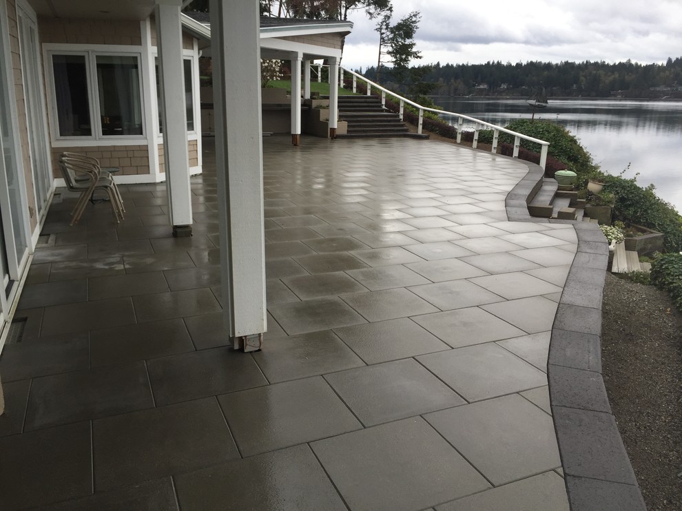 This is an example of a large modern back garden in Seattle with concrete paving.