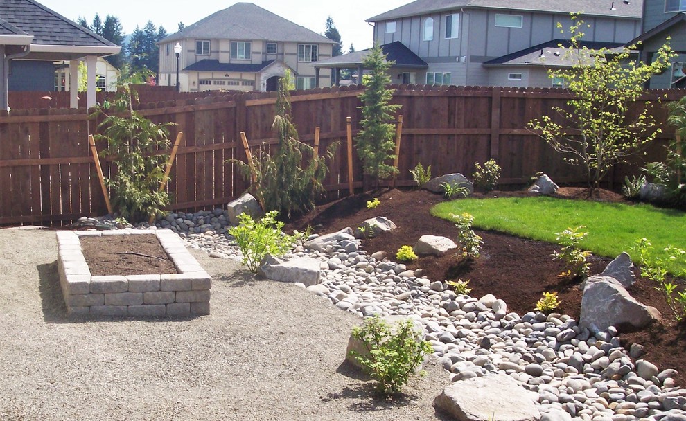 Photo of a drought-tolerant backyard gravel landscaping in Portland.