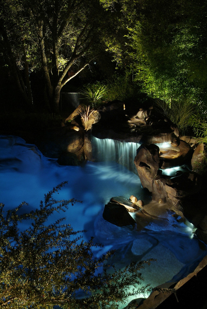 Photo of a huge contemporary full sun backyard stone water fountain landscape in Orange County.