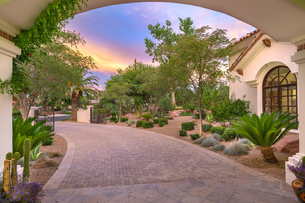 This is an example of a large mediterranean side driveway partial sun garden for summer in Las Vegas.