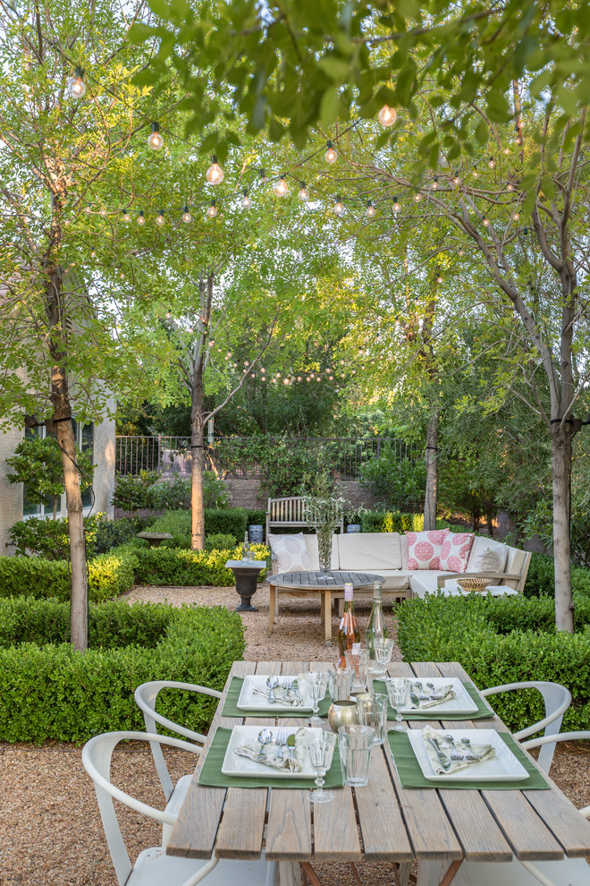 Cette image montre un jardin à la française arrière traditionnel de taille moyenne et l'été avec une exposition partiellement ombragée et du gravier.