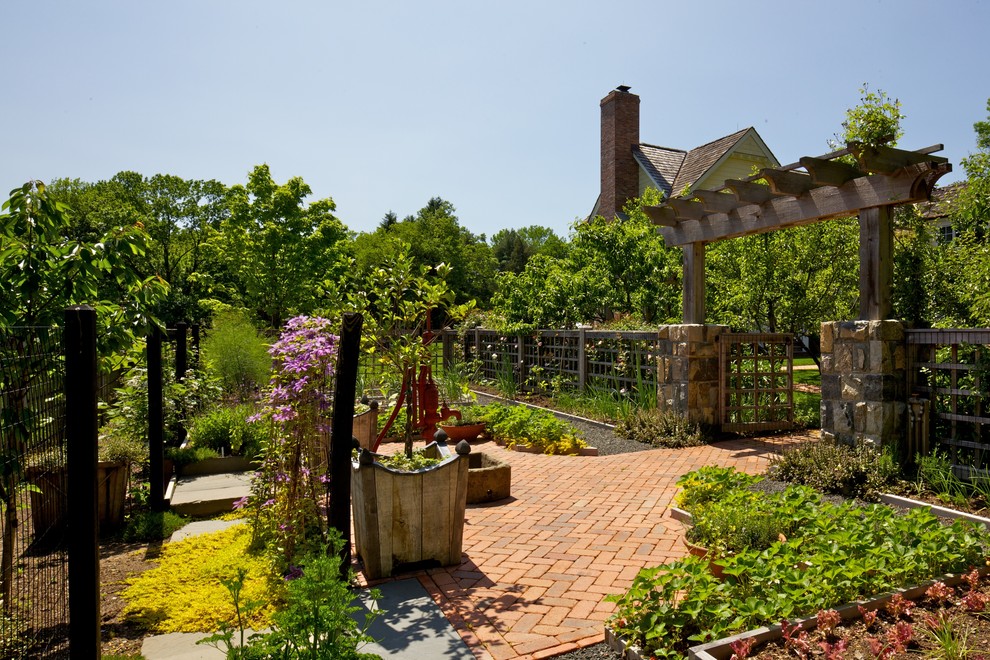 На фото: большой солнечный, летний регулярный сад на заднем дворе в классическом стиле с садовой дорожкой или калиткой, хорошей освещенностью и мощением клинкерной брусчаткой