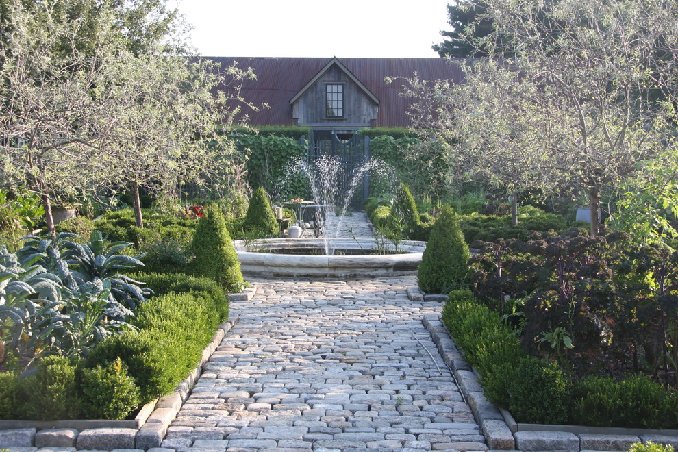 Bild på en stor lantlig trädgård, med en köksträdgård och naturstensplattor
