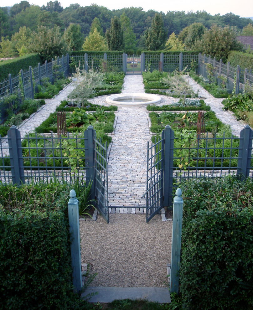 Bild på en stor lantlig trädgård, med en köksträdgård och naturstensplattor