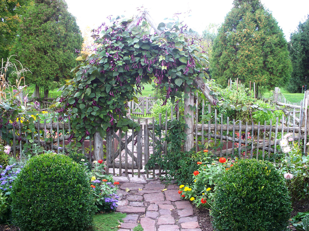 Modelo de jardín tradicional en patio trasero con adoquines de piedra natural