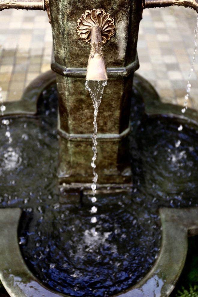 На фото: садовый фонтан среднего размера на внутреннем дворе в классическом стиле с полуденной тенью и мощением клинкерной брусчаткой с