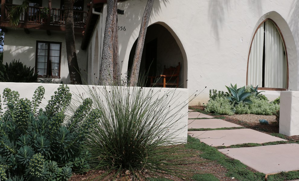 Medelhavsstil inredning av en mellanstor trädgård i full sol som tål torka och framför huset, med marksten i betong