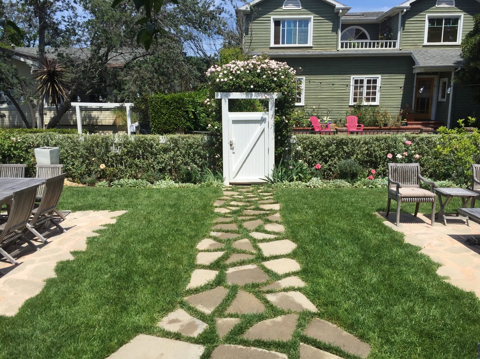 На фото: большой весенний регулярный сад на заднем дворе в морском стиле с садовой дорожкой или калиткой, полуденной тенью и покрытием из каменной брусчатки