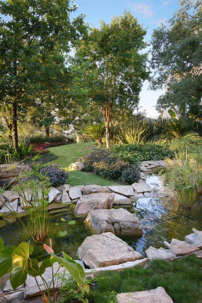 Modelo de jardín mediterráneo en patio trasero con fuente