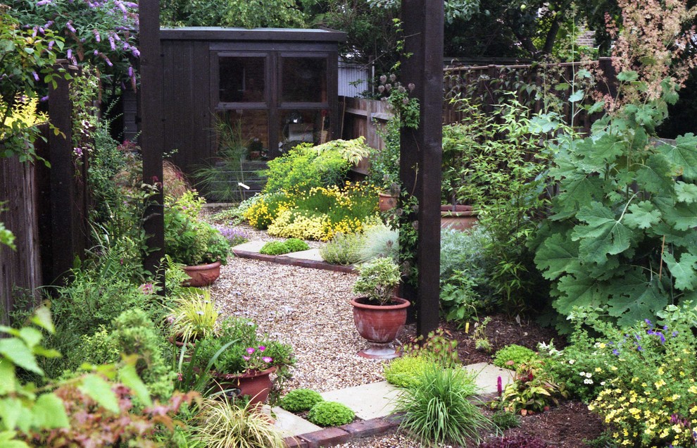 На фото: маленький солнечный, летний засухоустойчивый сад на заднем дворе в средиземноморском стиле с хорошей освещенностью и покрытием из гравия для на участке и в саду