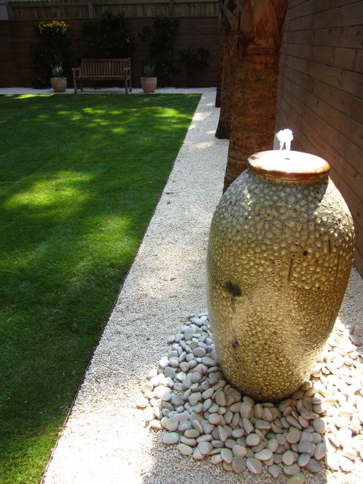 Ispirazione per un giardino moderno dietro casa con ghiaia e fontane