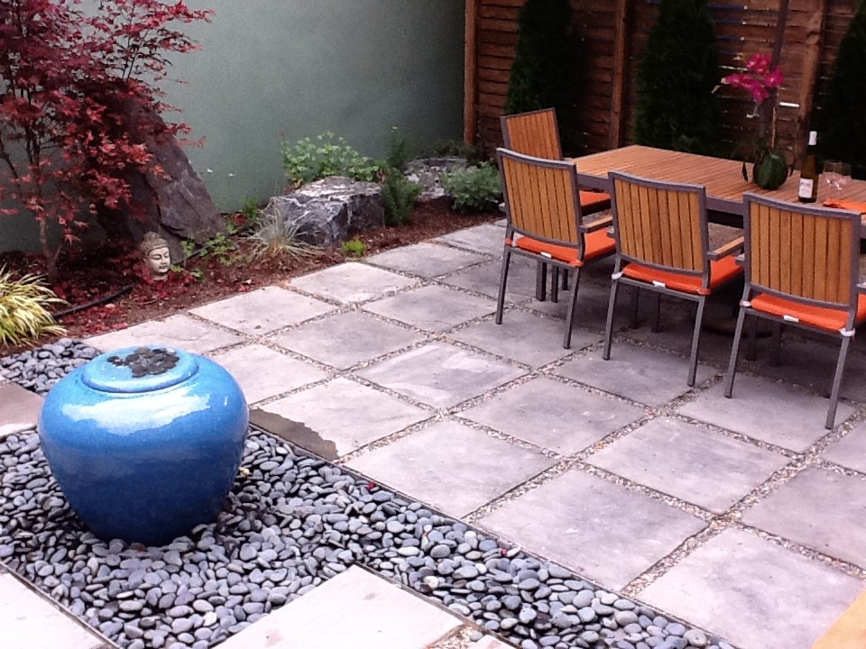Immagine di un piccolo giardino design esposto a mezz'ombra dietro casa in autunno con fontane e pavimentazioni in pietra naturale