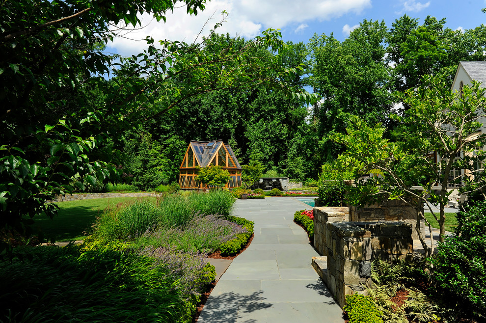 Imagen de jardín clásico de tamaño medio en patio trasero con jardín de macetas y adoquines de hormigón