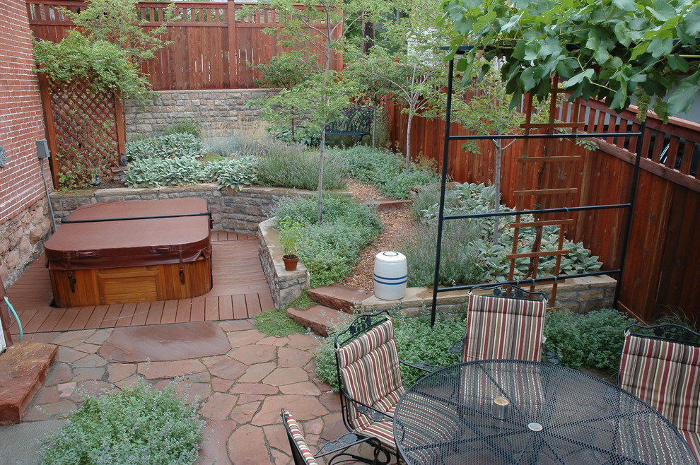 Design ideas for a small eclectic drought-tolerant and partial sun backyard stone retaining wall landscape in Salt Lake City for summer.