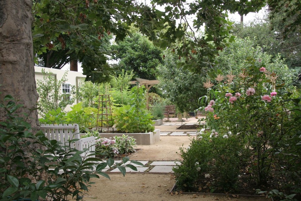 This is an example of a large classic back formal garden in Los Angeles with a garden path and natural stone paving.