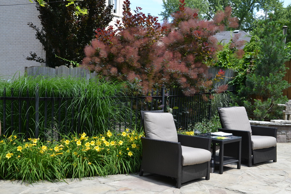 This is an example of a medium sized contemporary back full sun garden for summer in Toronto with natural stone paving.
