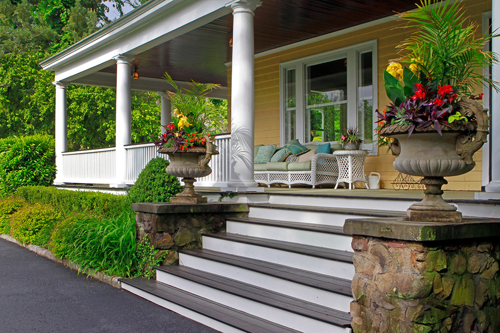 Photo of a large victorian front driveway partial sun garden in New York with a potted garden and decking.