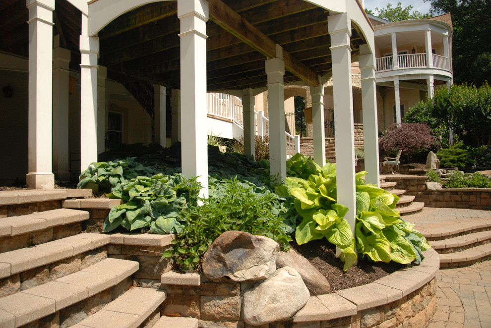 Esempio di un grande giardino eclettico esposto a mezz'ombra dietro casa in estate con un ingresso o sentiero e pavimentazioni in cemento