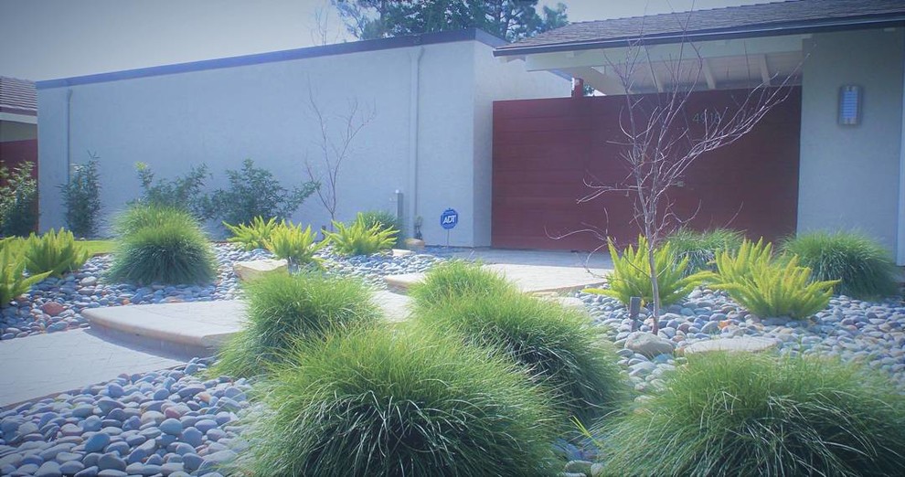 Idéer för en 50 tals trädgård som tål torka och framför huset, med en trädgårdsgång och marksten i betong