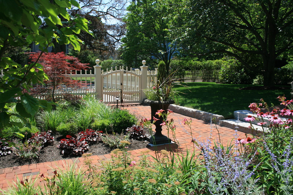 Foto de jardín clásico de tamaño medio en verano en patio delantero con jardín francés, exposición total al sol y adoquines de ladrillo