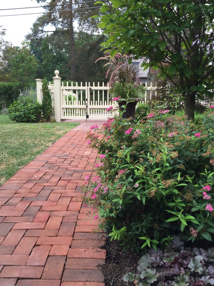 Photo of a medium sized victorian side formal full sun garden for summer in Boston with a garden path and brick paving.