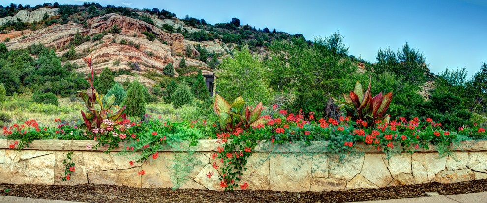 Inspiration for a large mediterranean partial sun hillside landscaping in Denver.