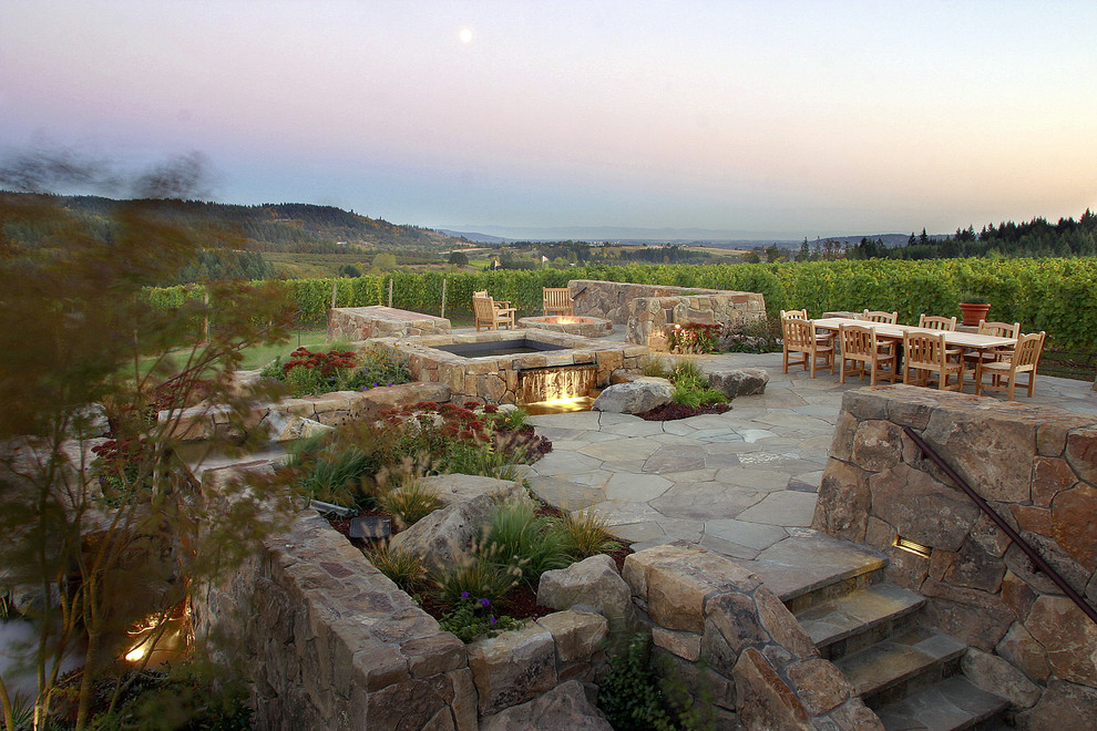 Photo of a large traditional back full sun garden in Portland with a water feature and natural stone paving.