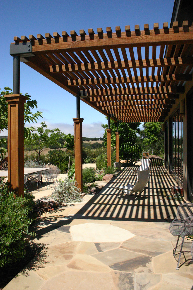 Стильный дизайн: участок и сад в современном стиле с покрытием из каменной брусчатки и с перголой - последний тренд