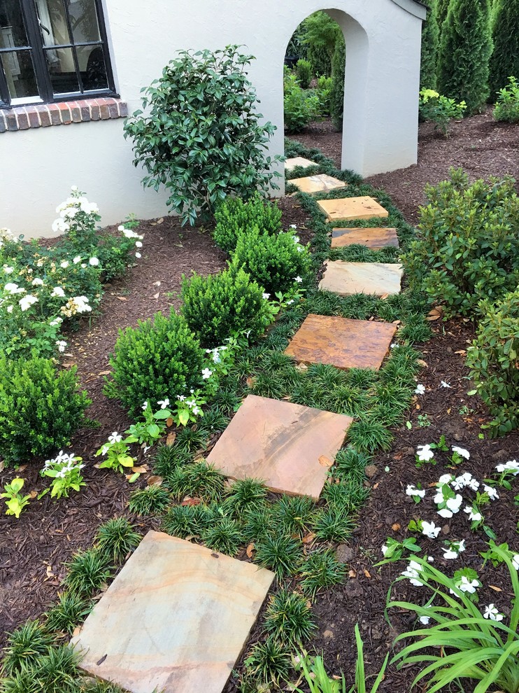 This is an example of a mid-sized rustic partial sun front yard stone garden path in Other.