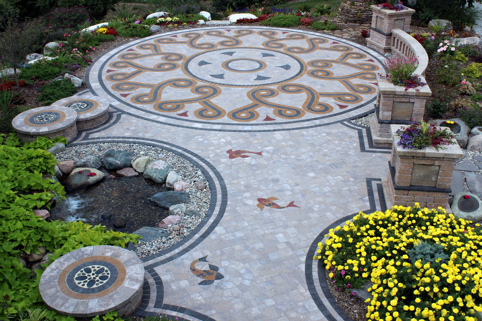 This is an example of a classic back garden in Omaha with a water feature and concrete paving.