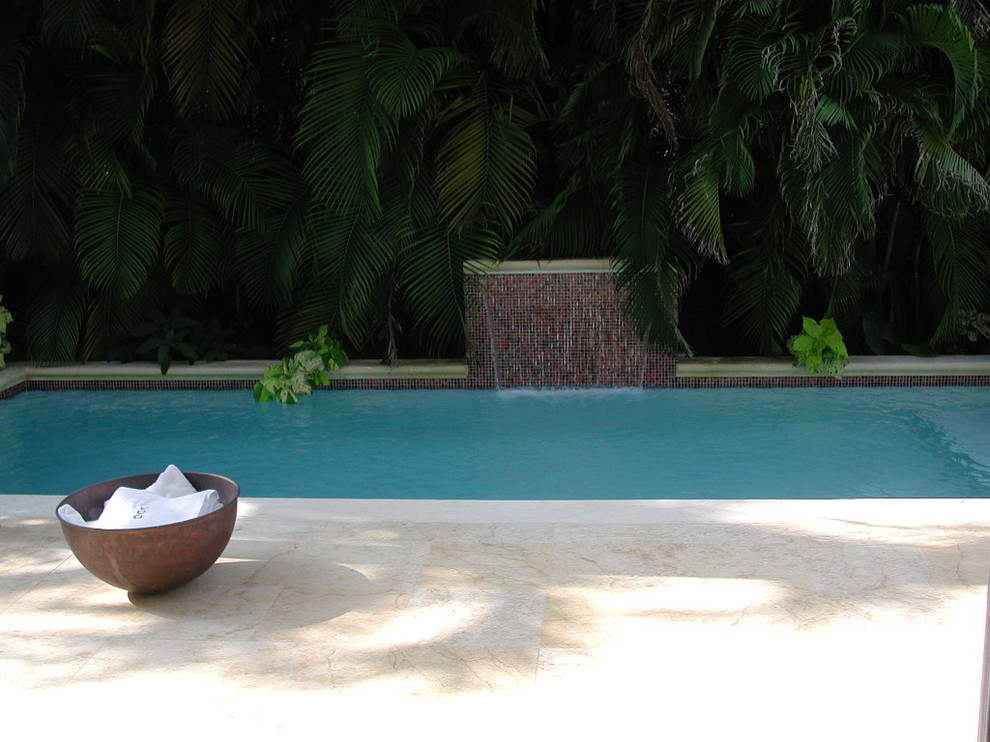 Photo of a tropical partial sun backyard stone water fountain landscape in Miami.