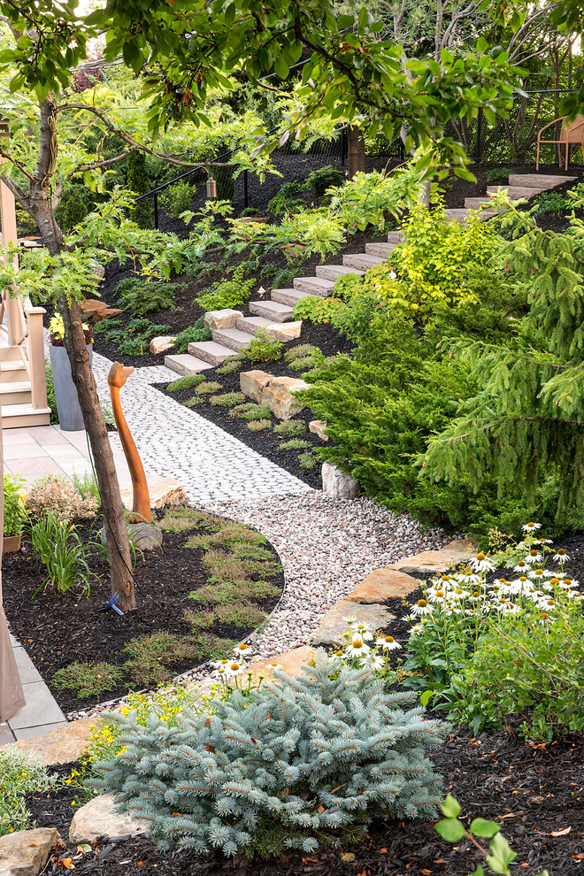Imagen de jardín de secano tradicional renovado grande en verano en patio trasero con muro de contención, exposición parcial al sol y adoquines de piedra natural