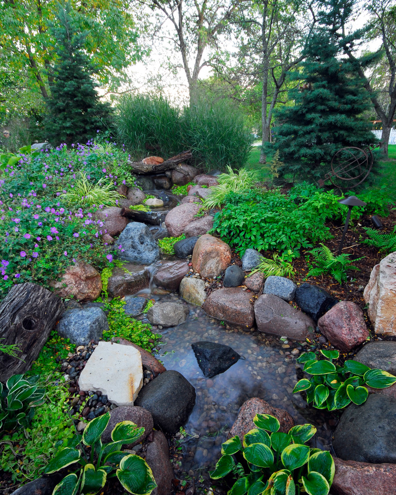 This is an example of a traditional garden in Milwaukee with a water feature.