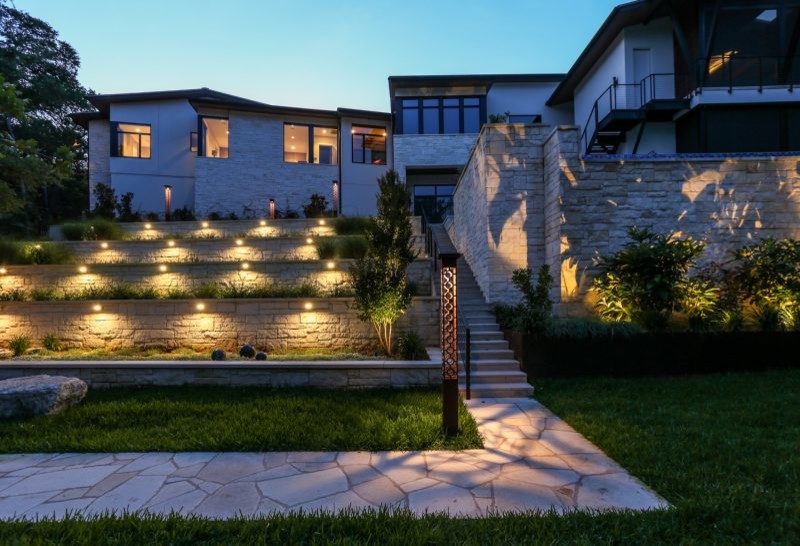 Design ideas for a large modern sloped garden in Austin with a retaining wall.