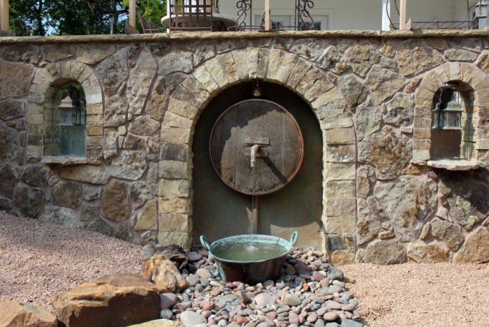Immagine di un giardino eclettico esposto in pieno sole di medie dimensioni e dietro casa con fontane e pavimentazioni in pietra naturale