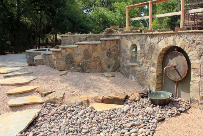 Photo of a mid-sized eclectic full sun backyard stone retaining wall landscape in Austin.