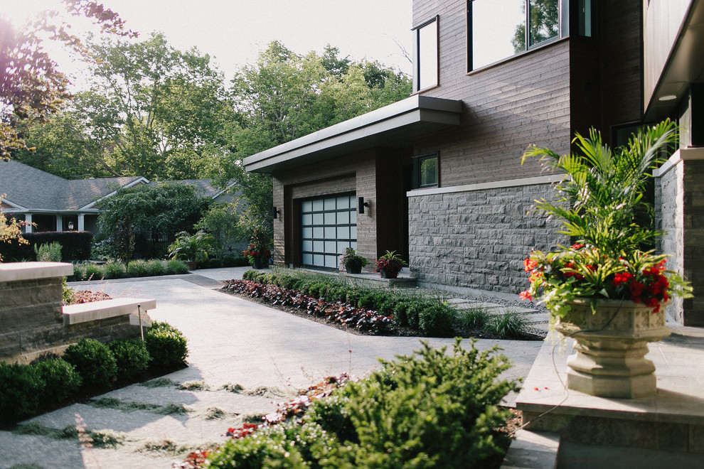 This is an example of a large midcentury front full sun garden for summer in Toronto with a garden path and concrete paving.