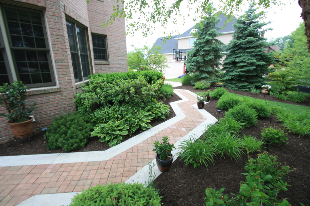 This is an example of a medium sized traditional side partial sun garden for summer in Cleveland with a garden path and brick paving.