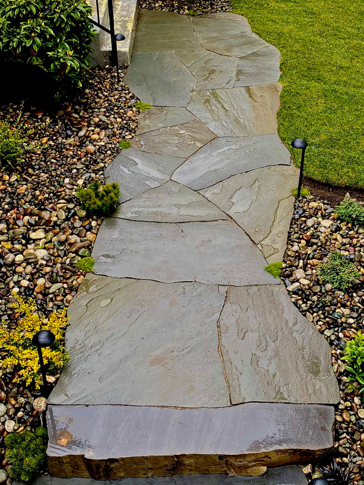 Inspiration for a rustic front yard river rock walkway in Vancouver.