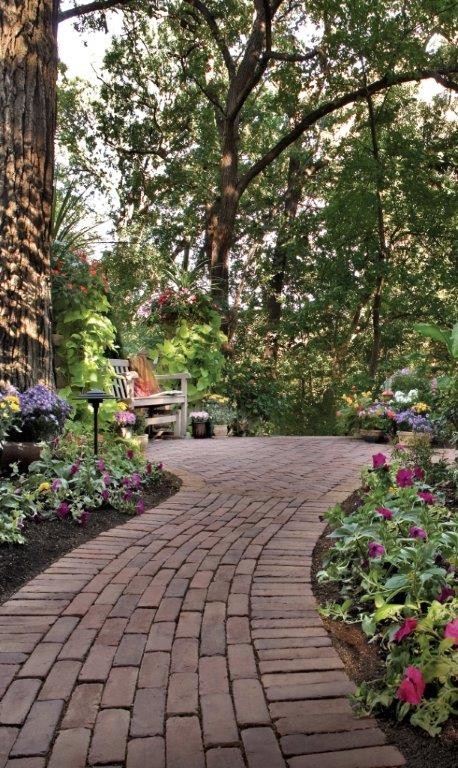 Photo of a large back formal partial sun garden for spring in New York with a garden path and brick paving.