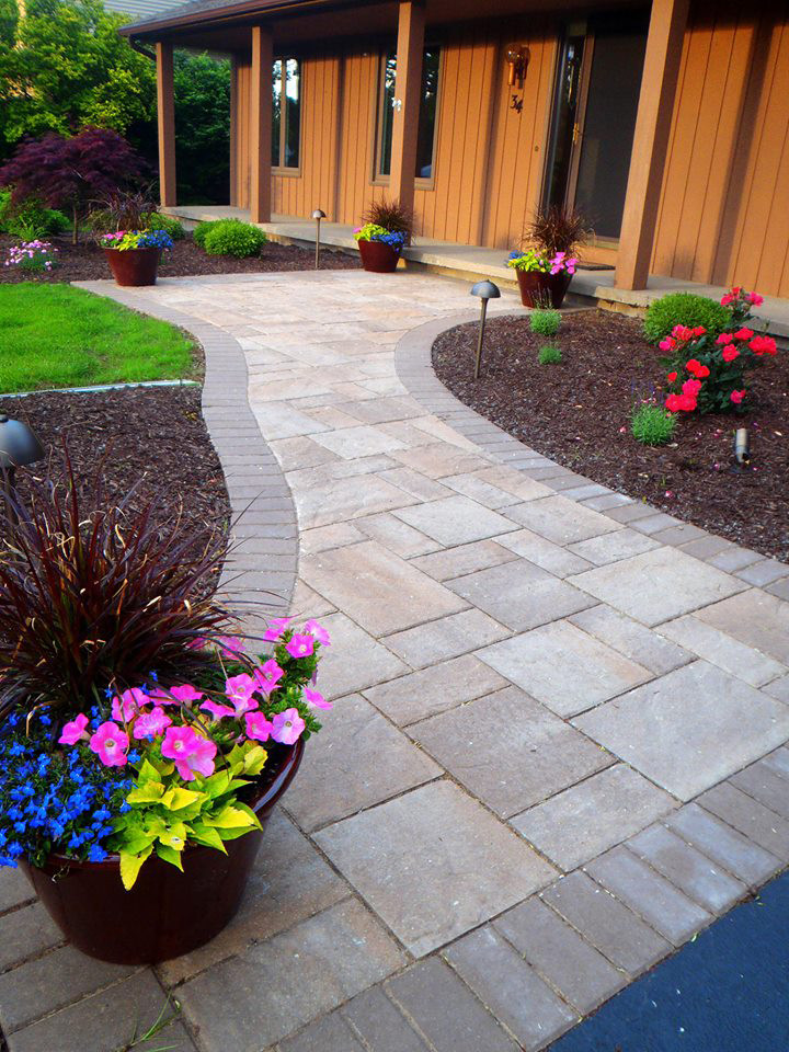 Photo of a medium sized classic front formal full sun garden for summer in New York with a garden path and natural stone paving.