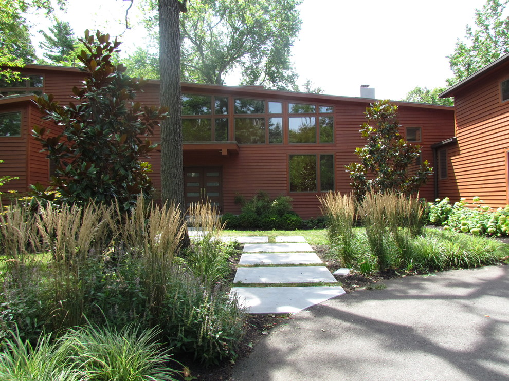 Exempel på en mellanstor modern trädgård framför huset, med marksten i betong