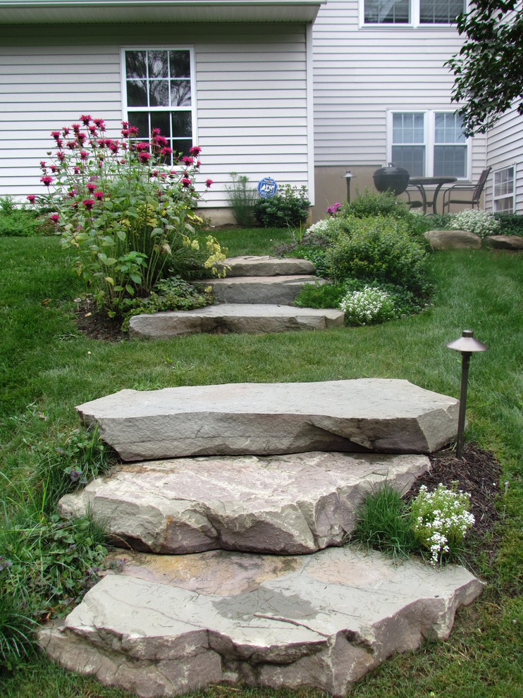 Photo of a mid-sized rustic backyard stone garden path in New York.