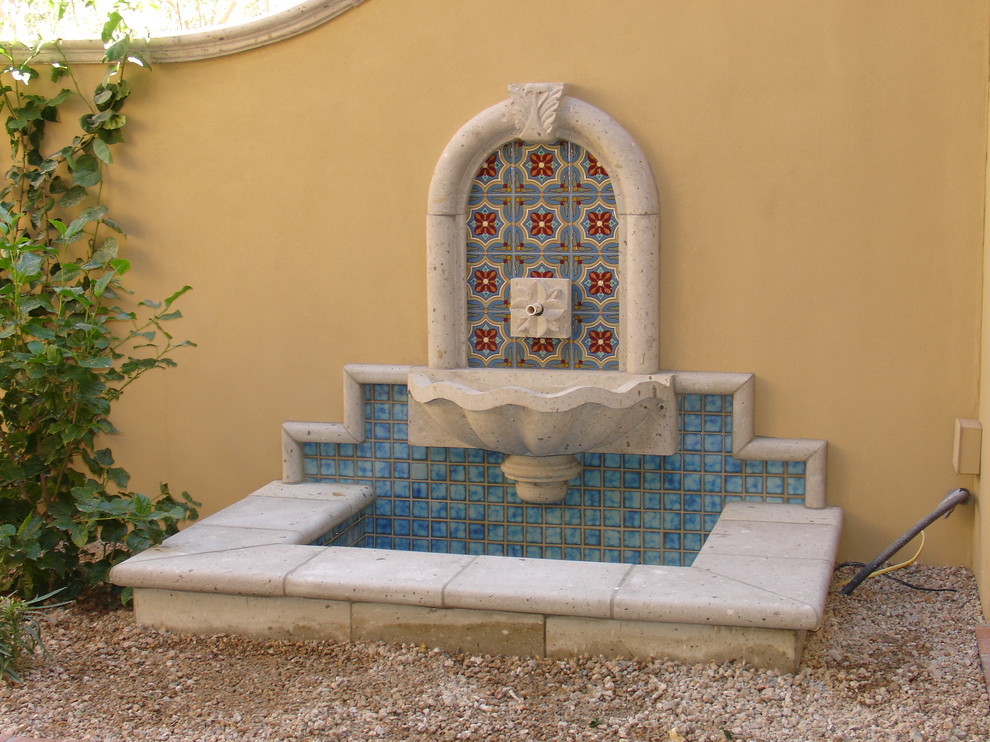 Imagen de jardín clásico de tamaño medio en patio trasero con fuente