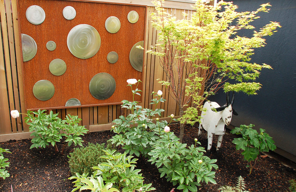 На фото: весенний засухоустойчивый сад среднего размера на заднем дворе в стиле кантри с полуденной тенью и мульчированием