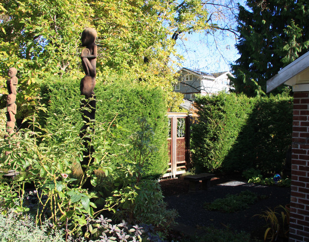 Small classic back formal and private partial sun garden in Seattle with gravel.