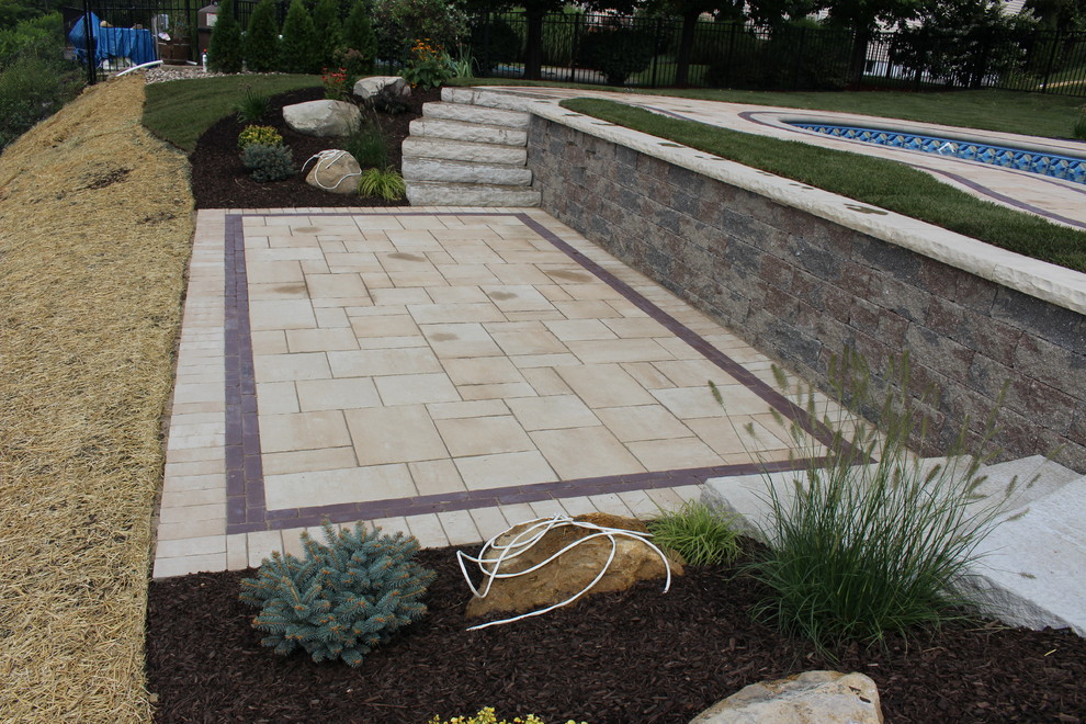 Photo of a small classic back formal full sun garden for summer in New York with a retaining wall and natural stone paving.